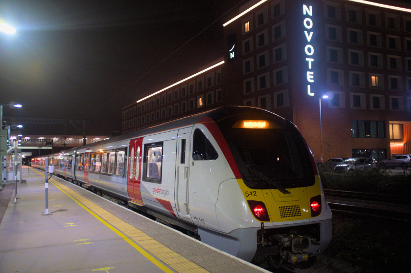 Class 720 720542 at Cambridge North station, with a bright Novotel sign in the background.