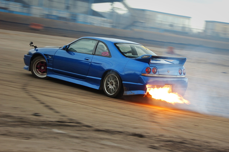 Peter Frary's Nissan Skyline R33 shooting flames from the exhaust on track.