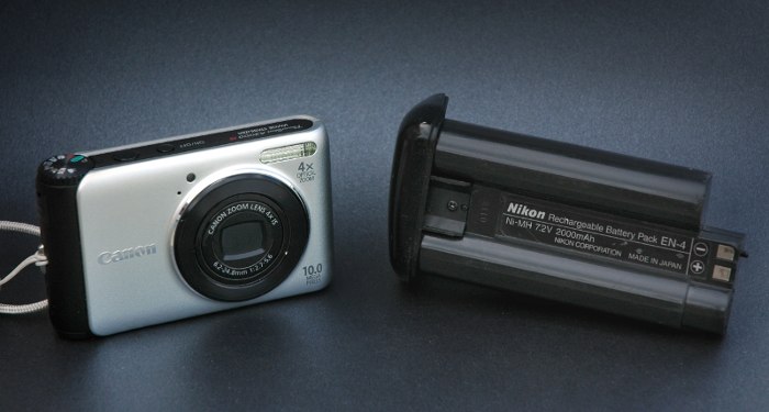 Nikon D1 battery dwarfing a Canon compact camera.